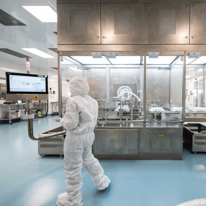 Image of a scientist in a full PPE suit in a pharmaceutical manufacturing environment